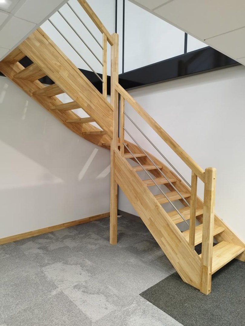 Escalier en bois ouvert avec garde-corps minimaliste en bois et métal dans un intérieur moderne.