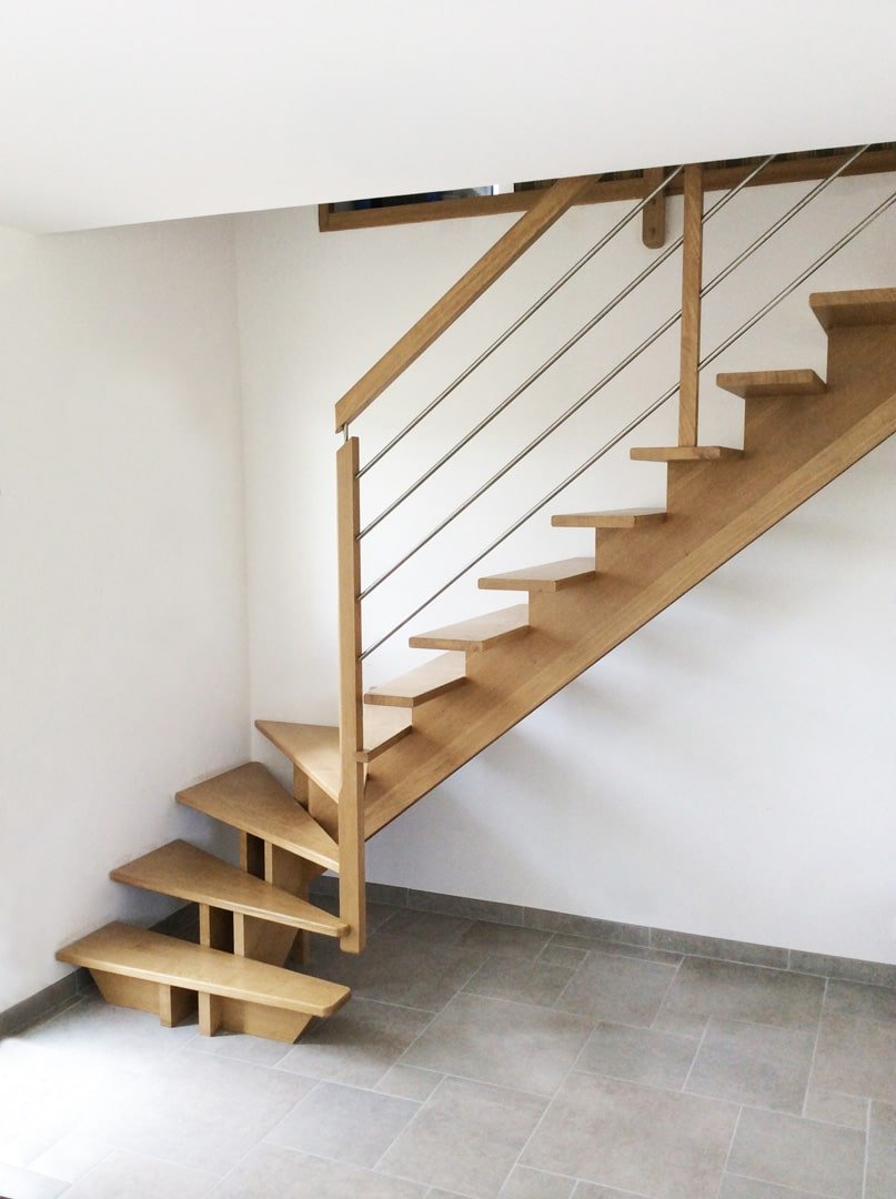 Escalier ouvert stylé en bois avec balustrade en fil métallique dans une maison moderne luxembourgeoise.