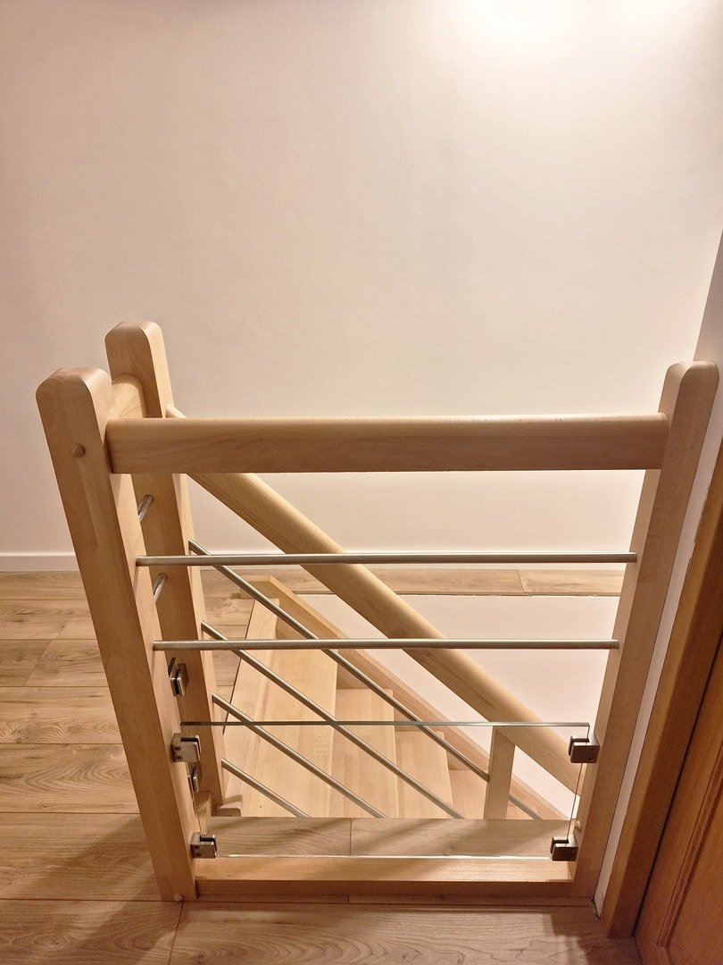 Vue de dessus d'un escalier en bois avec garde-corps moderne combinant bois et câbles métalliques.