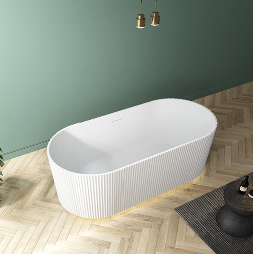 Baignoire autonome blanche avec des rainures verticales, située dans une salle de bain lumineuse avec un sol en chevrons en bois clair, des murs vert sauge, et de