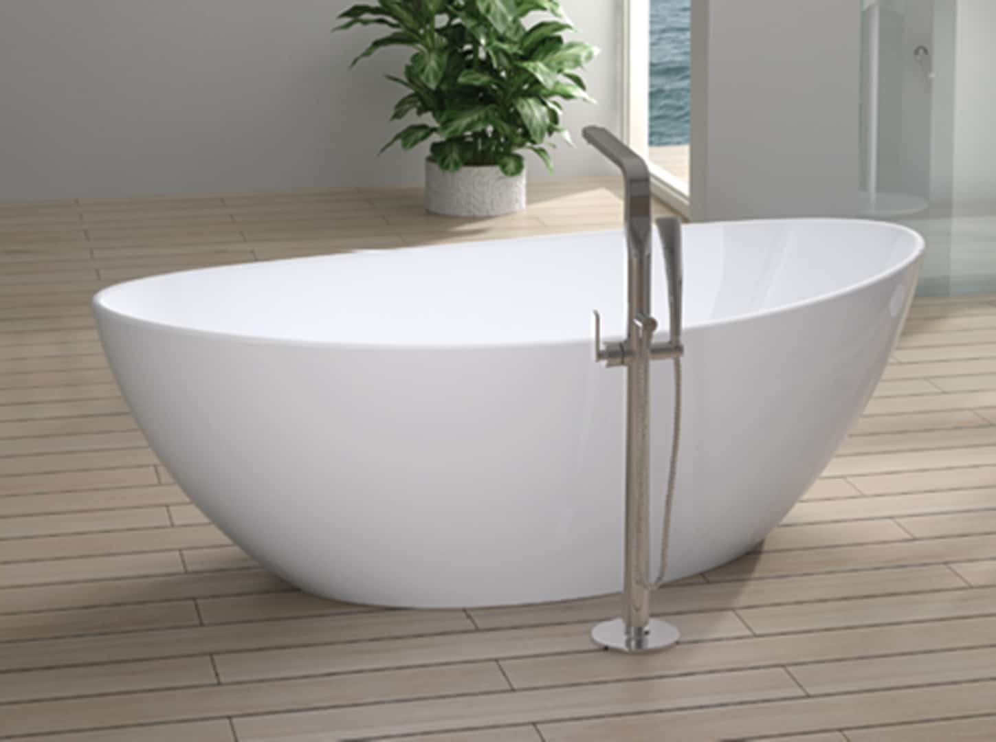Baignoire blanche ovale élégante sur un sol en bois clair, dans une salle de bain spacieuse avec un pot de plante verte, vue sur la mer, et un robinet sur pied en