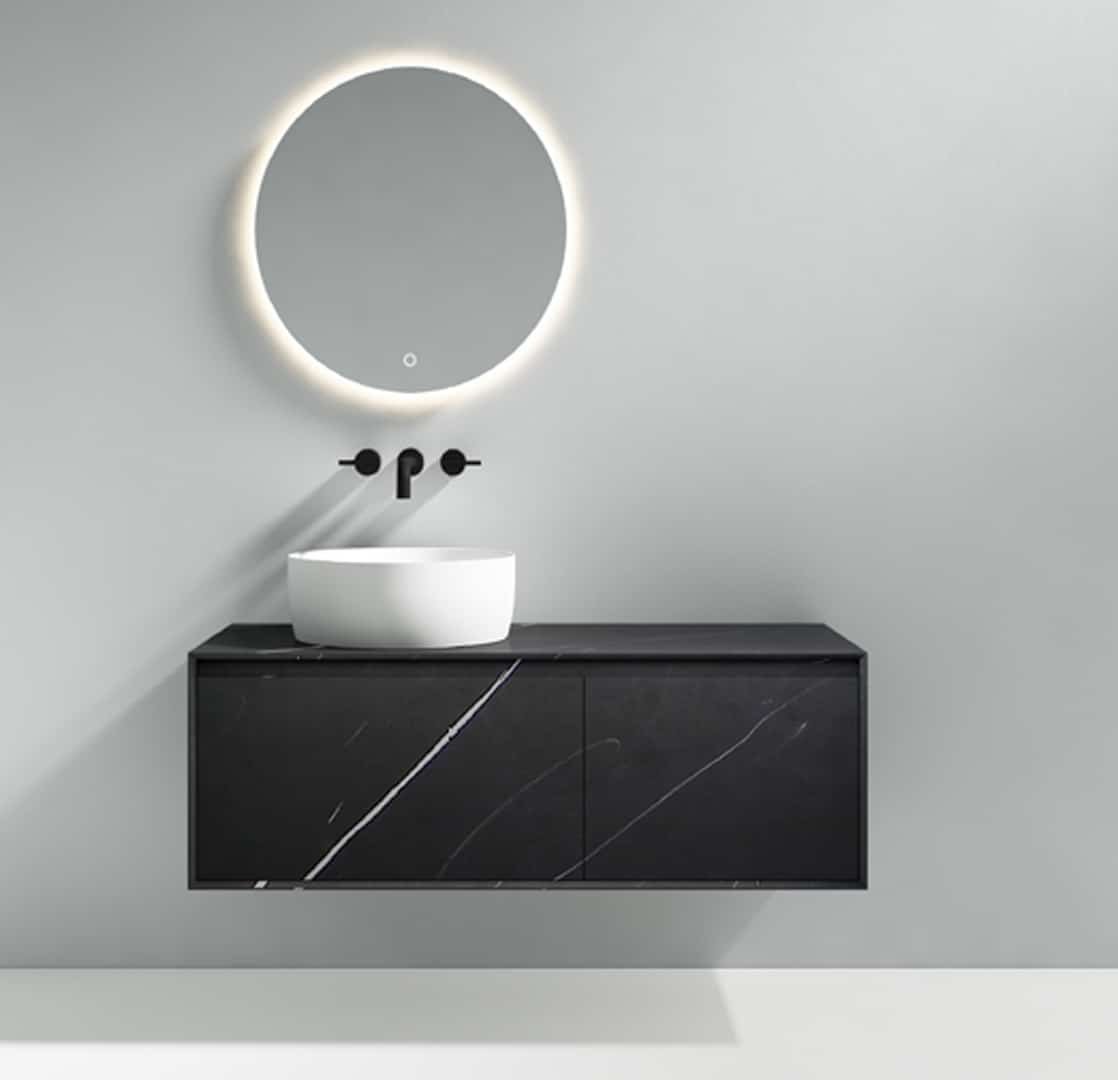 Meuble-lavabo noir élégant avec une surface en marbre noir veiné de blanc, surmonté d'un lavabo rond et un miroir circulaire avec éclairage